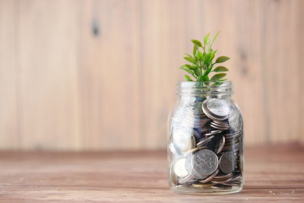 A jar filled with coins and a plant symbolizes growth in savings and investment.